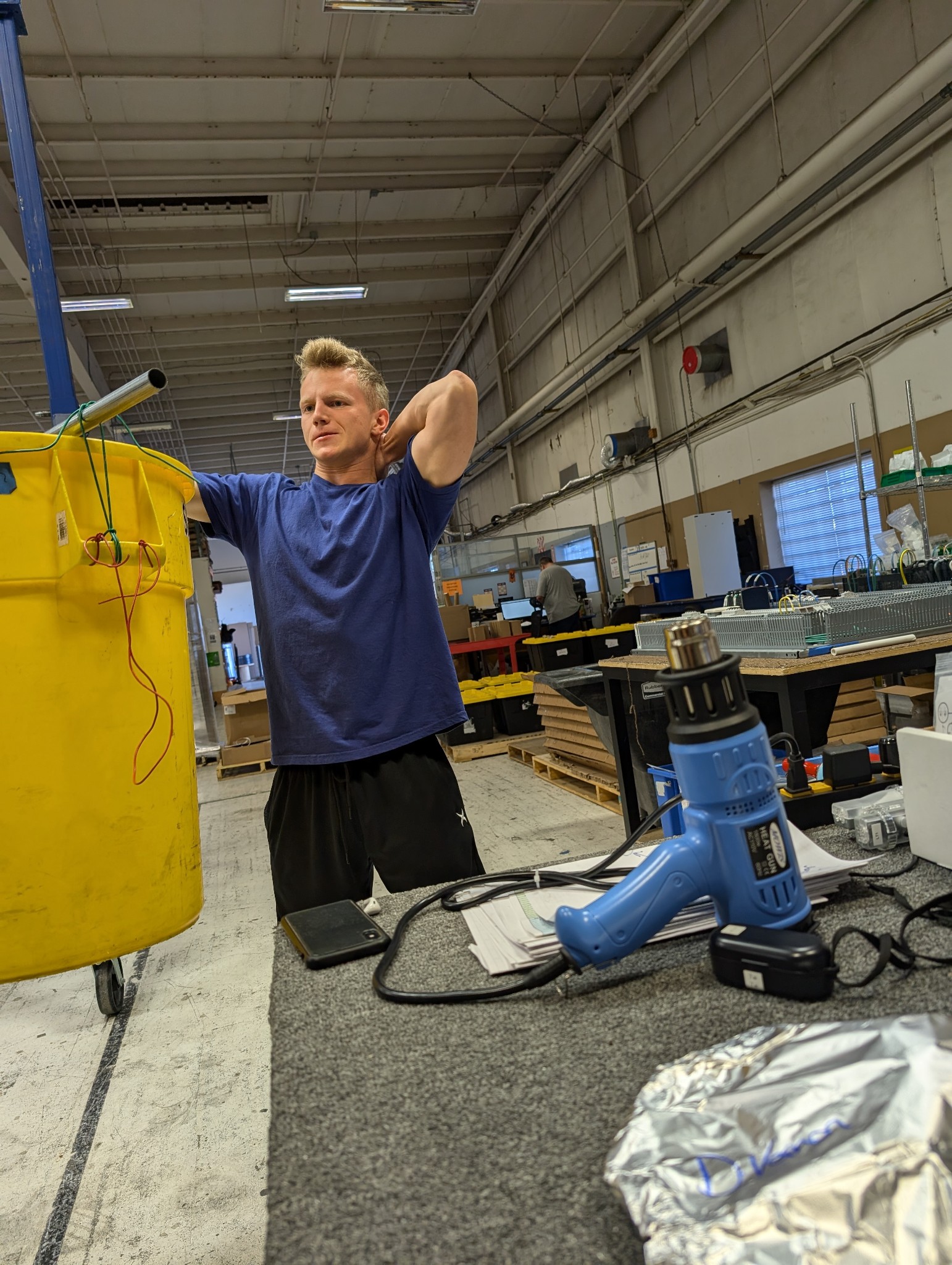 Young man holding a bin in the air in front of him.