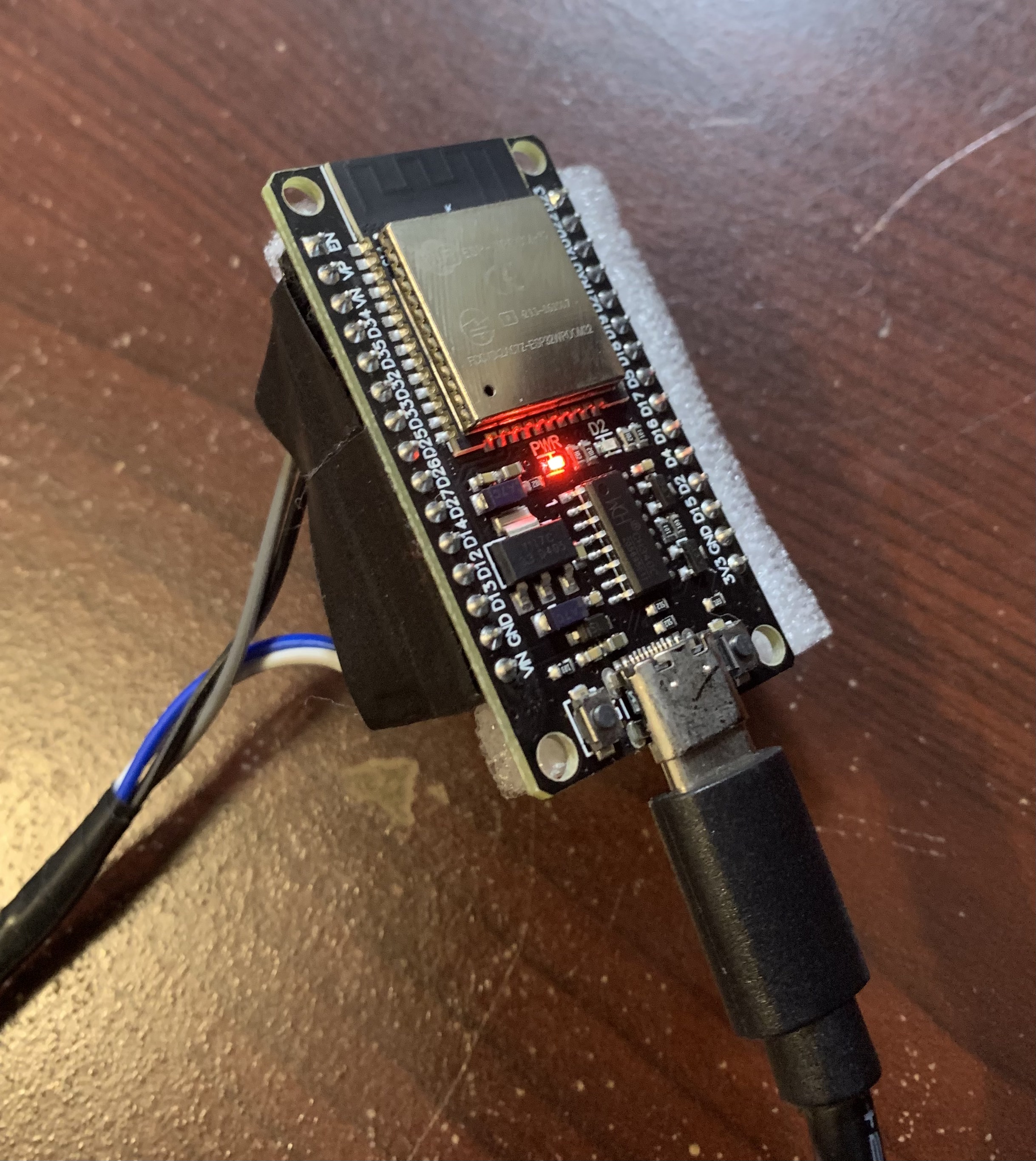 An ESP32 microcontroller connected to wires.